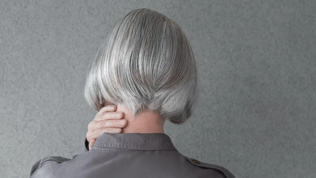 Mujer con canas al natural mostrando cómo cuidar las canas y evitar que se pongan amarillas